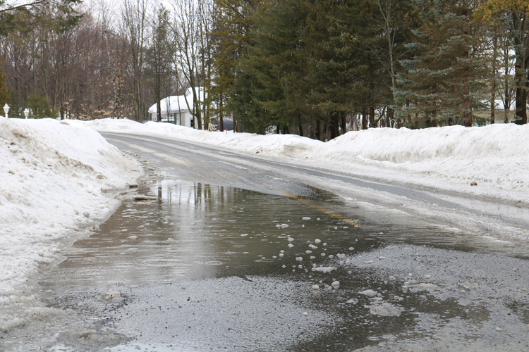 Puddles are seen flooding the streets of Saint-Lazare, Que. in the middle of February