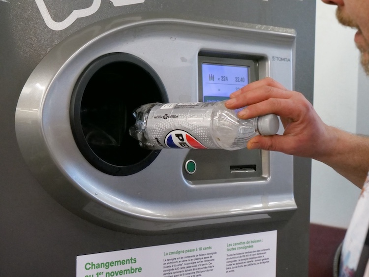 Aveline returns his donated cans and bottles at an IGA on Wellington Street in Verdun, earning a total of $32.80 from a quick morning pickup run.