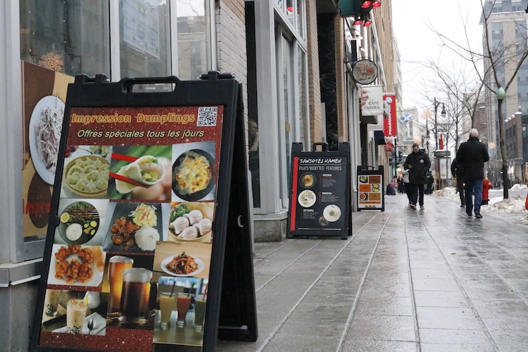 Promotional signs on the sidewalk in front of restaurants