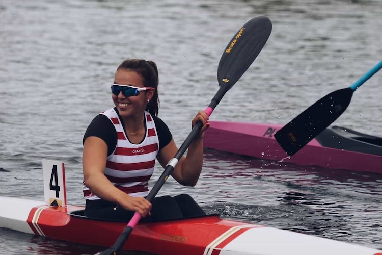 Person in her Kayak smiling with her paddle in her hand.