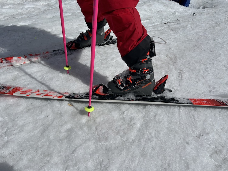 Close-up of skis, poles, and ski boots on the mountain.